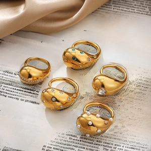 Close-up of gold-plated rings with colorful gemstones on vintage book pages
