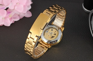 Détails d'une montre mécanique dorée avec fond de boîtier transparent et bracelet acier