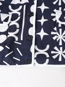 Dettaglio del motivo geometrico su giacca blu navy con profili bianchi e bottoni neri