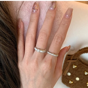Detail of silver twisted rings with brushed metal texture and sparkling zircon stones