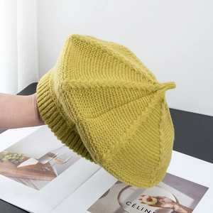 Macro detail of ginger yellow knitted beret showing fine wool texture and six-panel structure