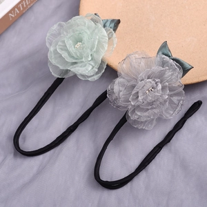 Detailed view of grey and mint green fabric flower hair bun makers with pearl centers