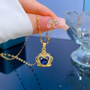 Close-up of golden crown pendant with large blue sapphire zircon and fine chain