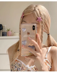 Gros plan de barrettes roses en forme d'étoile sur une coiffure tressée blonde