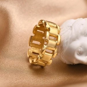 Close-up of gold chain link ring on silk background with artistic plaster sculpture
