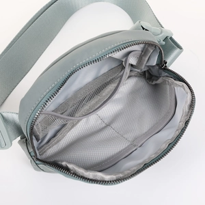 Light gray blue athletic belt bag with internal mesh compartments and adjustable strap