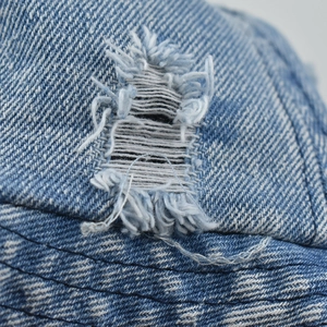 Close-up of distressed washed denim fisherman hat with vintage frayed edges and texture