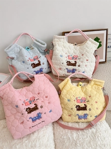 Detail of four colorful quilted cotton tote bags with cute cartoon embroidery