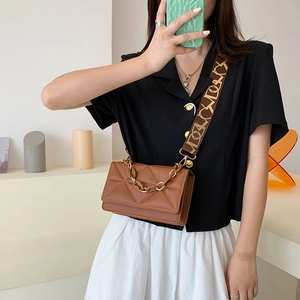 Brown quilted crossbody bag with gold chunky chain and wide patterned shoulder strap
