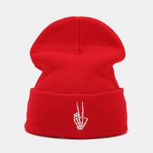 Détail du bonnet rouge avec broderie blanche de main de squelette sur le revers