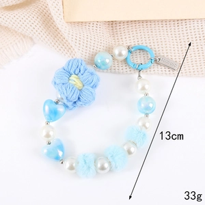 Detail showing 13cm beaded phone charm with blue crochet flowers and white pearls