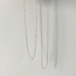 Macro view of two 925 sterling silver necklaces featuring paperclip and thin link chains
