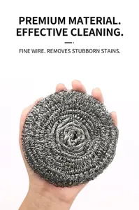 Close-up of a large stainless steel scouring ball for kitchen cleaning held by hand