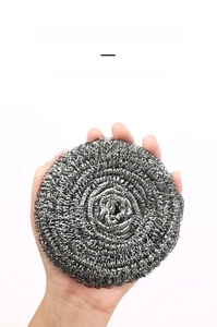 Close-up of a large stainless steel scouring ball for kitchen cleaning held by hand
