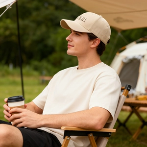 Homme portant une casquette beige brodée AA et un t-shirt décontracté assorti en plein air
