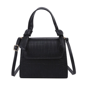 Fashionable black faux crocodile skin handbag with decorative bow handle and shoulder strap