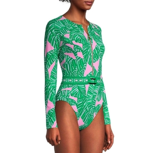 Detail of long sleeve swimsuit with green leaf print, front zipper, and waist belt