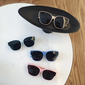 Polarized TR90 children's sunglasses in beige, mint, purple, and pink on a white table