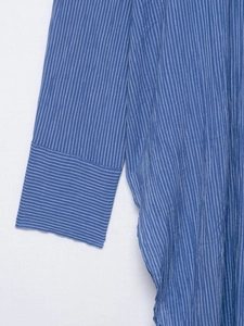 Détail de chemise rayée montrant la texture contrastée sur les poignets