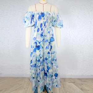 Detail of blue and white floral off-shoulder maxi dress with tiered cake skirt design