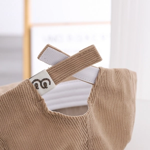Détail de la sangle velcro réglable et de la texture velours du bonnet pour enfant