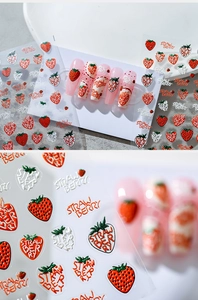 Detail of 3D embossed strawberry nail decals with vibrant red fruit patterns