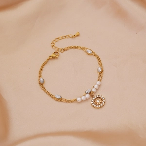Gold double-layered stainless steel pearl bracelet with starburst pendant on silk
