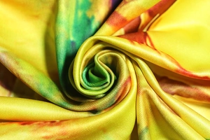 Detailed macro view showing the smooth textile texture and colorful tie-dye print pattern