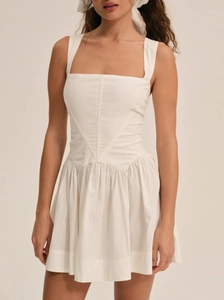 Detalle de minivestido blanco con escote cuadrado y diseño tipo corsé en cintura