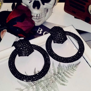 Gothic style large black rhinestone hoop earrings displayed on a white frame background
