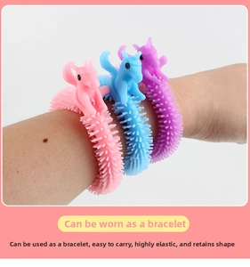 Close-up of three colorful unicorn sensory stretch bracelets worn on a wrist for stress relief