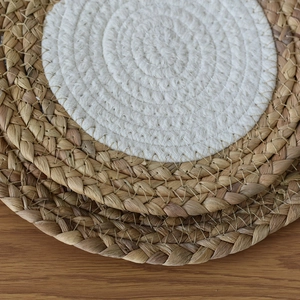 Detailed close-up of a woven cotton and straw placemat with intricate stitching texture