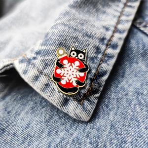 Niedliche Emaille-Anstecknadel: Schwarze Katze mit roter Weihnachtskugel und Schneeflocke