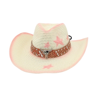 Détail d'un chapeau de cowboy en paille avec étoiles roses et ornement tête de bœuf