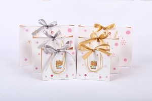Detailed close-up of floral bear gift bags with golden handles and ribbon bows