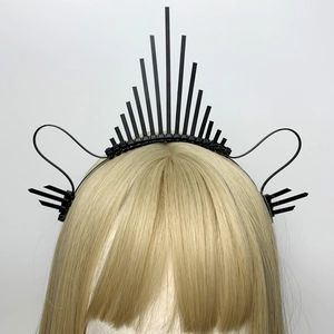 Detail showing spikes and curved lines of this black gothic crown headband on a gold mannequin
