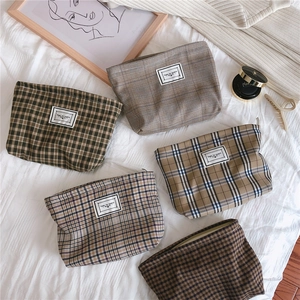 Detailed flat lay of vintage checkered cosmetic bags with retro zipper and fabric label