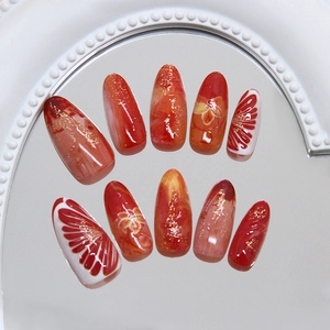 Handmade red almond press-on nails with 3D floral art and gold glitter finish
