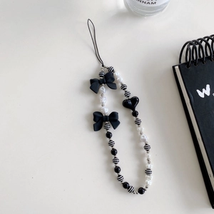 Minimalist beaded phone strap with black bows, heart pendant and white pearls