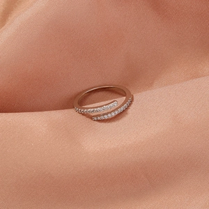Macro shot of rose gold ring with white zircon pave setting on spiral cross band