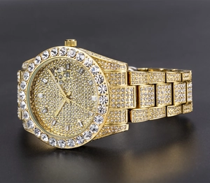 Detailed macro of a gold iced-out watch with crystal diamonds and date display window
