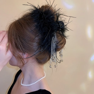 Close-up of black fluffy feather hair claw clip with sparkling rhinestone fringe tassels