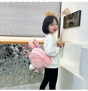 Pink toddler backpack featuring rabbit ears and a fluffy white pom-pom tail detail
