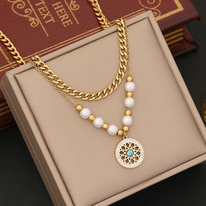 Detailed shot of gold layered necklace with pearl chain and turquoise sunburst pendant