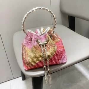 Dettaglio borsa a secchiello con strass sfumati rosa arancio e manico rotondo