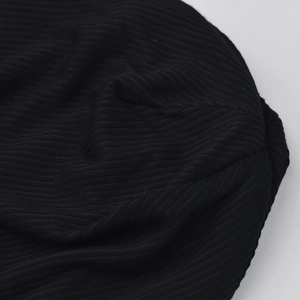 Gros plan sur un bonnet en tricot noir côtelé avec texture élastique et détails brodés
