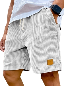 Close-up of brown leather label on men's white striped corduroy casual shorts