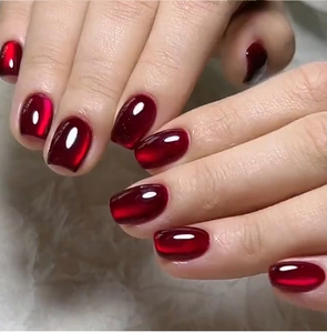 Macro detail of dark red cat-eye press-on nails with a high-gloss jelly texture finish