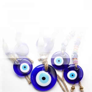 Macro detail of blue glass Evil Eye charms with jute rope and colorful beads