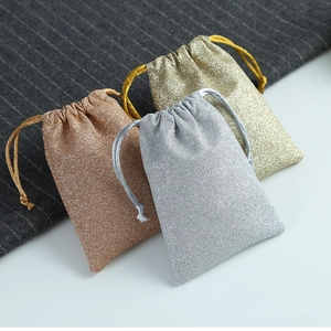 Macro detail of sparkly gold, rose gold and silver drawstring jewelry gift pouches
